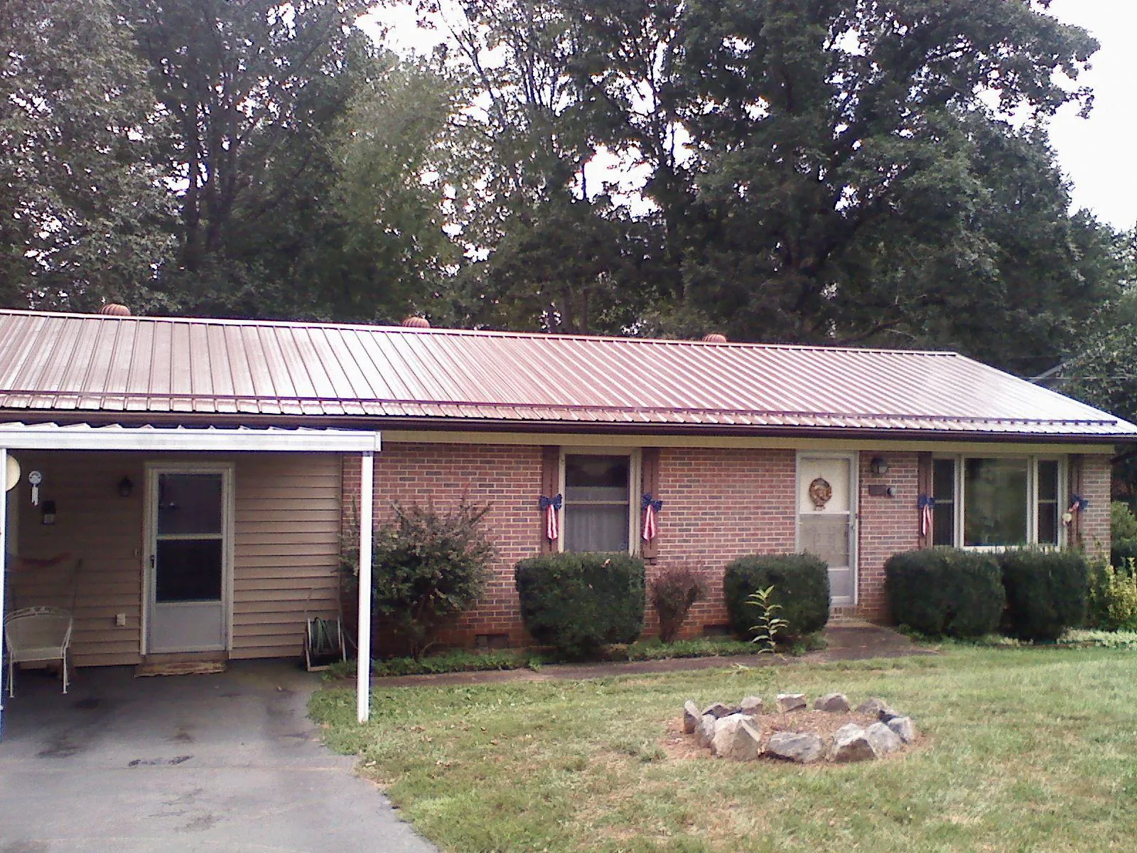 Bronze metal roof and carport on a brick ranch home — Roof Repair work by our crew in Roxbury